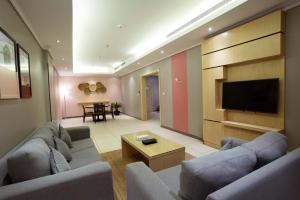 a living room with couches and a flat screen tv at Dara Salam in Jeddah