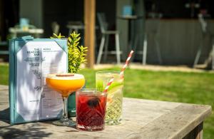 two drinks sitting on a wooden table next to a bag at Solent Hotel and Spa in Fareham