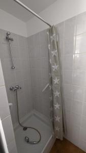 a bathroom with a shower with a shower curtain with stars at Appartement de village in Monacia-dʼAullène