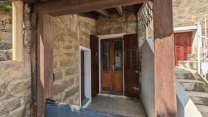 an entrance to a house with a wooden door at Appartement de village in Monacia-dʼAullène