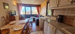 une cuisine et un salon avec une table dans une pièce dans l'établissement Etendard N 522 - 4P7, à Les Deux Alpes 7 autres photos