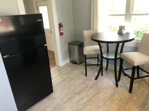 eine Küche mit einem schwarzen Kühlschrank sowie einem Tisch und Stühlen in der Unterkunft Suite 39 North in Lebanon