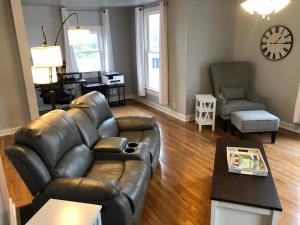 ein Wohnzimmer mit einer Ledercouch und einem Tisch in der Unterkunft Suite 39 North in Lebanon