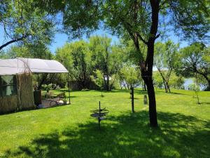 a park with a tent and a tree in the grass at Fisheagle Hut in Orania in Orania