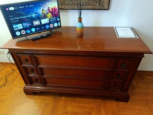a wooden dresser with a television on top of it at Camera Emma in Florence