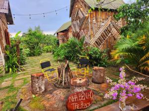 a garden with chairs and a wooden building at Nhà Bên Hồ 2- The Peace's House in Ấp Thánh Hương