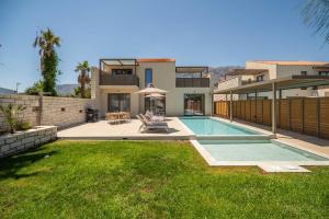 Un patio trasero con piscina y una casa. en Villa Zen Hephaistos by PosarelliVillas, en Asprouliánoi