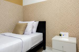 a bedroom with a bed with white sheets and pillows at Cove Padonan Inn in Dalung