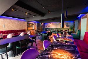 a restaurant with purple tables and chairs at Centrum Hotel in Akureyri