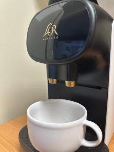 a coffee maker with a cup on a table at Nomad Haux in the heart of Tossa 7 in Tossa de Mar
