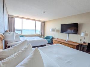 a hotel room with two beds and a flat screen tv at Confederation Place Hotel in Kingston