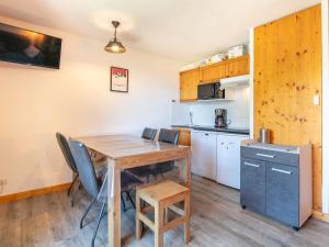 Les Grizzlis N 24 - 2P5 في سانت سورلين دوارفيز: مطبخ وغرفة طعام مع طاولة وكراسي