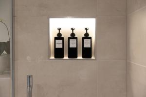 tres botellas de vino sentadas en un estante en un baño en Apartment 2, en York