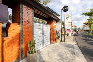 a brick building with a gate on a street at Cove Padonan Inn in Dalung