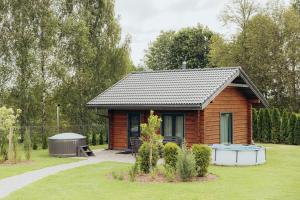 a small cabin in a garden with a gazebo at Dūjas in Duķuri