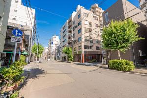 een lege straat in een stad met hoge gebouwen bij Sheath Okachimachi Apartment Hotel in Tokyo
