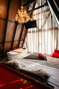 ein Zimmer mit einem Bett mit Badewanne und einem Kronleuchter in der Unterkunft Chalé de Luxo em São Pedro de Alcântara - SC in São Pedro de Alcântara