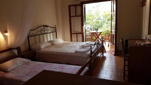 a bedroom with two beds and a door to a patio at Castello Bellos studios in Marathias +7 photos