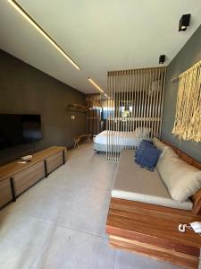 a living room with a couch and a bed at Vilas Manatee - Praia do Patacho in Pôrto de Pedras
