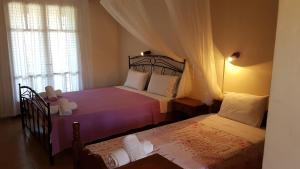 a bedroom with two beds and a window at Castello Bellos studios in Marathias