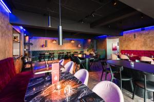 a restaurant with tables and chairs and a bar at Centrum Hotel in Akureyri