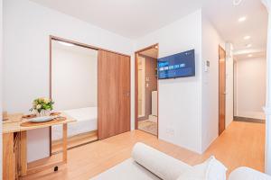 een kamer met een bed en een bureau met een televisie bij Sheath Okachimachi Apartment Hotel in Tokyo