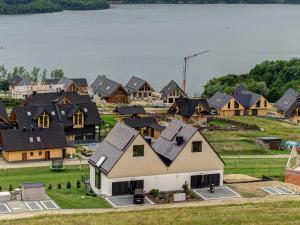 un grupo de casas con un lago en el fondo en Miral Apartament nad Jeziorem Czorsztyńskim, en Kluszkowce