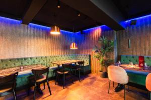 a restaurant with tables and chairs and blue lights at Centrum Hotel in Akureyri