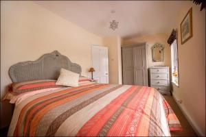 a bedroom with a large bed and a dresser at Rhos Ddu in Criccieth