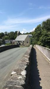 a road with a stone wall next to a house at Rhos Ddu in Criccieth