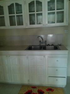 a kitchen with white cabinets and a sink at Spacious Colonial in Bridgetown