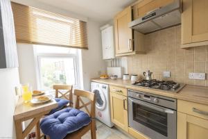 a kitchen with a stove top oven next to a table at Bridge View in Oxford