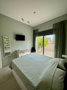 a bedroom with a bed and a tv and a window at Vakantiewoning Alegria in Finestrat +25 photos