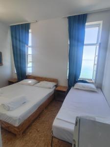 two beds in a room with a window at Guest house Lori in Pogradec +22 photos