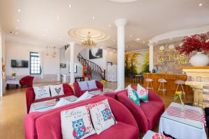 a living room with red couches and a fireplace at Lotus Luxury Villa Da Lat in Da Thien