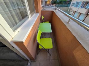 two green chairs and a table on a balcony at Paradise Studio NBU in Sofia
