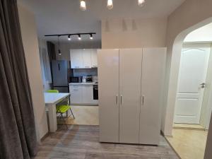 a kitchen with white cabinets and a table at Paradise Studio NBU in Sofia +2 photos