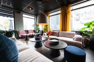 a living room with couches and tables and windows at Centrum Hotel in Akureyri