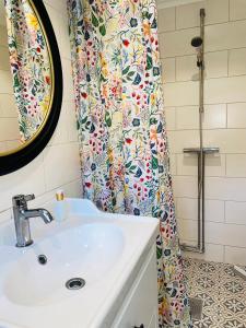 a bathroom with a sink and a shower curtain at Stugan Karmaleily in Gävle