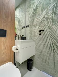 Un baño con lavabo blanco y ducha. en Miral Apartament nad Jeziorem Czorsztyńskim, en Kluszkowce