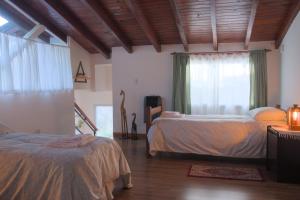 サン・カルロス・デ・バリローチェにあるBienvenidos al Relax Bed & Breakfastのベッド2台と窓のある寝室