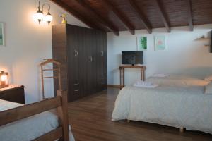 サン・カルロス・デ・バリローチェにあるBienvenidos al Relax Bed & Breakfastのベッドルーム1室(ベッド2台、キャビネット、テレビ付)