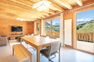 a dining room with a table and chairs and a large window at Chalet les Buffettes - 4P8 in Saint-Jean-dʼArves