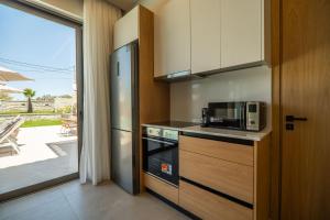 una cocina con estufa y microondas en Villa Zen Hephaistos by PosarelliVillas, en Asprouliánoi