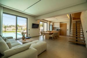 una sala de estar con un sofá y una mesa en Villa Zen Hephaistos by PosarelliVillas, en Asprouliánoi