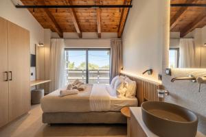 1 dormitorio con cama, lavabo y ventana en Villa Zen Hephaistos by PosarelliVillas, en Asprouliánoi 35 fotos más