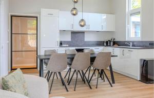 a kitchen with white cabinets and a table and chairs at Awesome Home In Voorthuizen in Voorthuizen