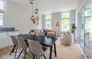 a kitchen and dining room with a black table and chairs at Awesome Home In Voorthuizen in Voorthuizen