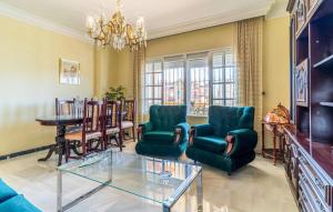 a living room with a table and chairs and a chandelier at 3 Bedroom Amazing Apartment In Torre Del Mar in Torre del Mar