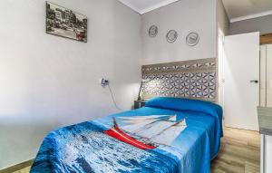 a bedroom with a bed with a painting of a boat at Gorgeous Apartment In Algarrobo With Wifi in Algarrobo +9 photos